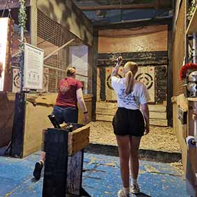  Two female members of our staff throwing axes at targets 