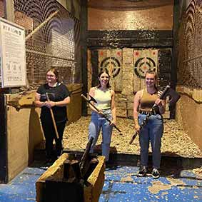  Three women holding axes to show they placed 1st, 2nd and 3rd during axe throwing 