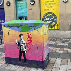  Street art on a bin of a black and white boy with a colourful background 