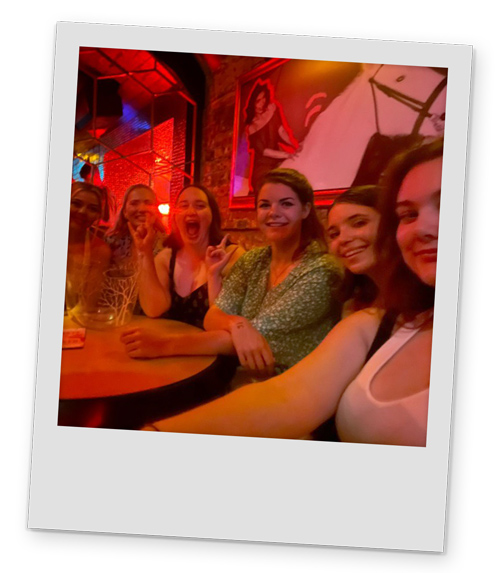 Six female members of LNOF staff crowded around a table in Ollie's nightclub
