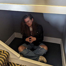 Hannah L sat in a space under the stairs 