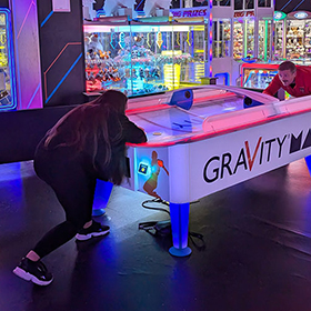 Adam and Christie engaged in a game of air hockey 