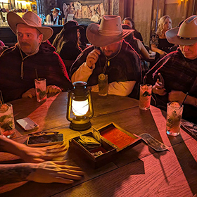  Team LNOF sat around a table in cowboy hats and ponchos 