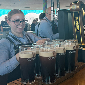  A female bartender who has poured about eight glasses of Guinness 
