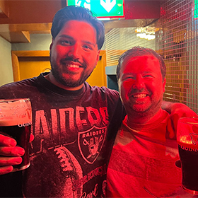  Akash and Will posing in a bar with pints of Guinness