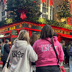  Two members of LNOF staff wearing LNOF hoodies looking at Temple Bar with their backs to the camera 