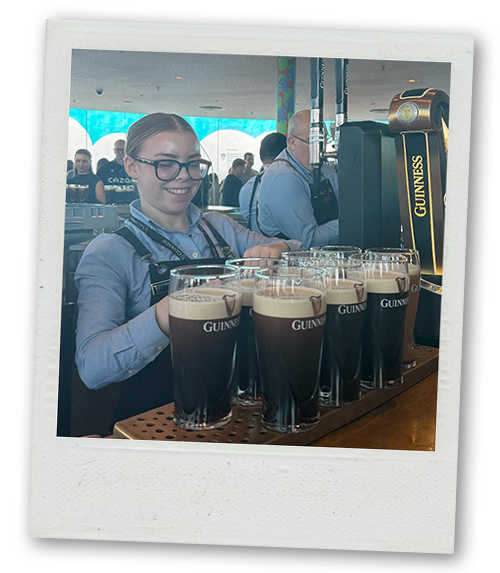 A bartender pouring loads of pints of Guinness in the Gravity Bar at the Guinness Factory Tour