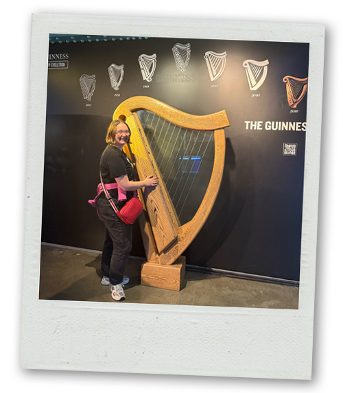 Hannah posing with a big harp at the Guinness Factory Tour