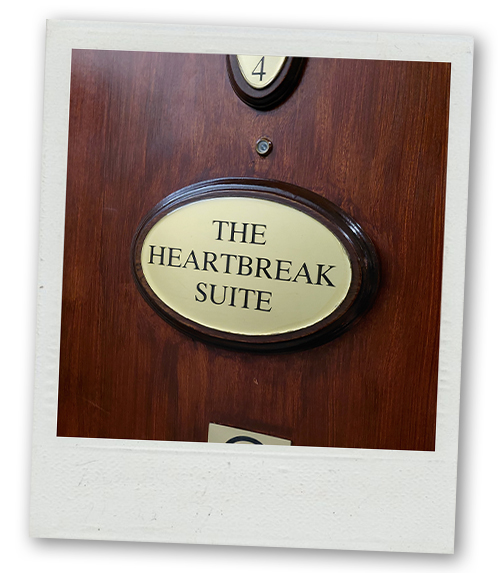 A hotel door room at the Harcourt which reads The Heartbreak Suite