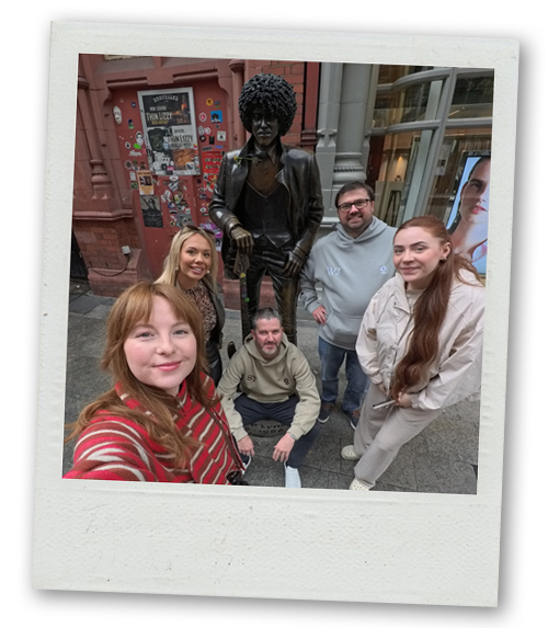 Team LNOF posing with a statue of a musician in Dublin city centre