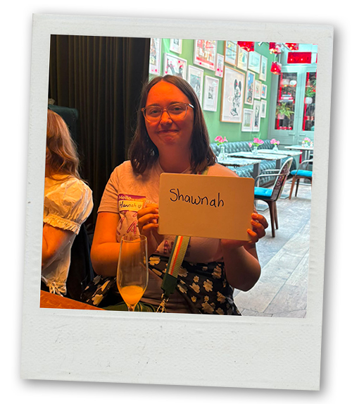 Hannah holding up a whiteboard that reads Shawnah