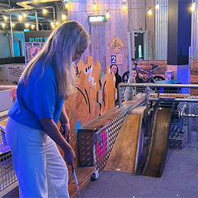  A female member of staff playing crazier golf at Boom Battle Bar 