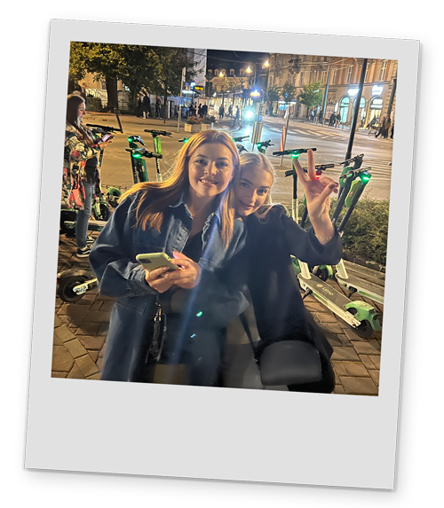 A polaroid style image of two of our Team LNOF posing in front of Krakow's scooters