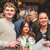  A blonde man, a brunette woman and a blonde woman (students from Northumbria) stood in a row holding drinks. 
