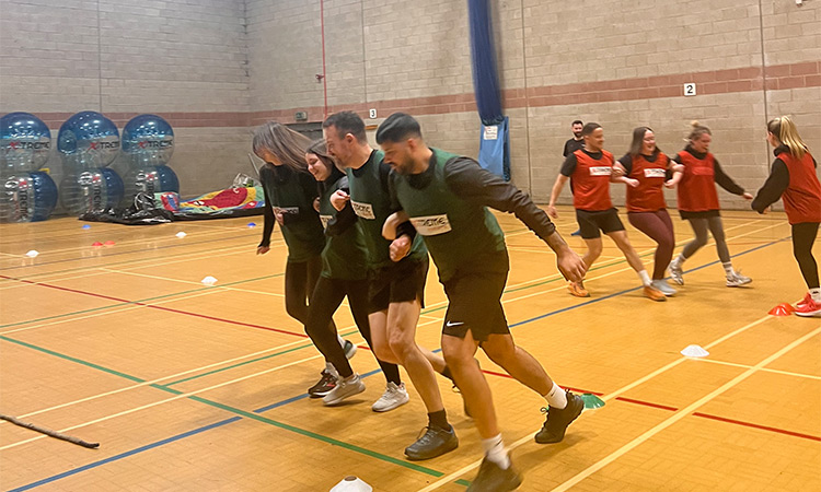 Two teams of LNOF staff racing each other with arms interlinked