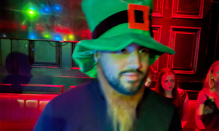 Akash wearing a green Irish hat and a ginger wig