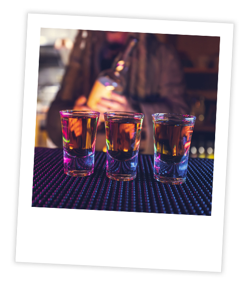 A Polaroid of three shots sitting on a bar