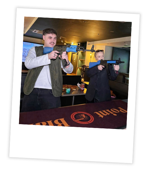 A Polaroid of two men who are shooting virtual reality guns at Point Blank