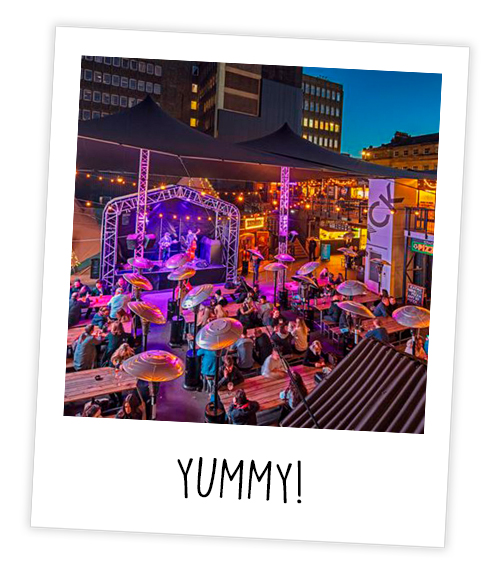 A Polaroid of St James’ Stack in the evening with a band playing with the caption Yummy