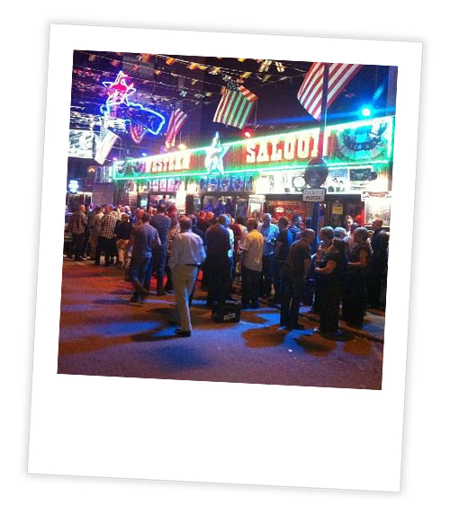 A Polaroid of people crowded outside of the bar Western Saloon