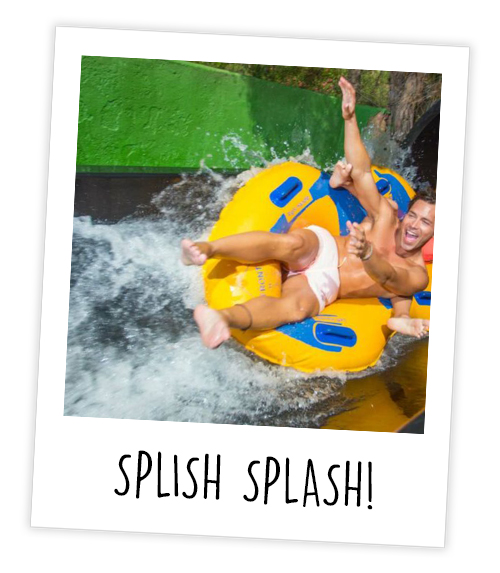 A Polaroid of two people in a rubber ring going down a water slide which is captioned Splish Splash!