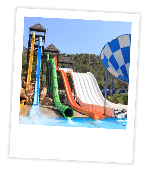 A Polaroid of six different water slides that are all in a row including two very tall ones