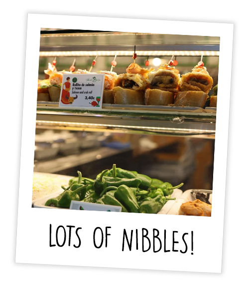 A Polaroid of a counter that has crab rolls in it which is captioned with Lots of Nibbles