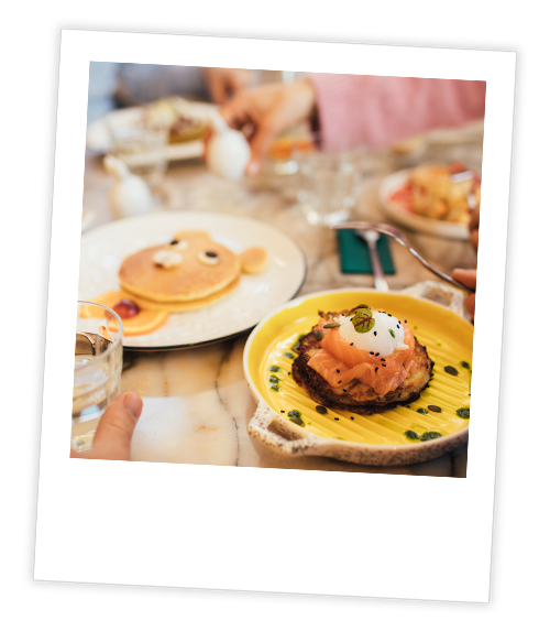 A Polaroid of a selection of brunch dishes including a smoked salmon dish and a pancake dish