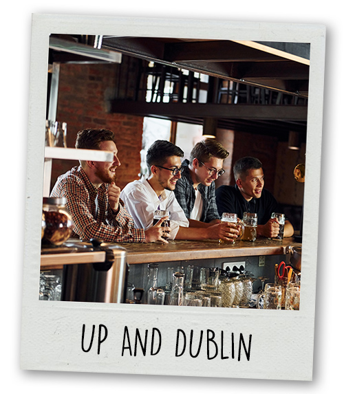 A Polaroid of four men drinking in a bar with the caption up and dublin