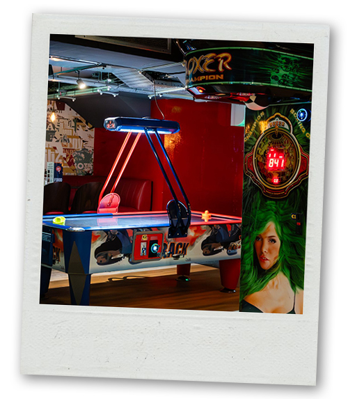 A Polaroid of an air hockey and a punching machine