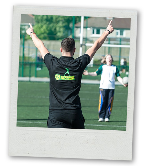 A Polaroid of a referee blowing his whistle at someone playing Gaelic handball