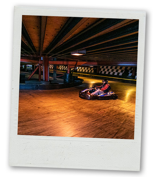 A Polaroid of a man taking the corner on a go karting track