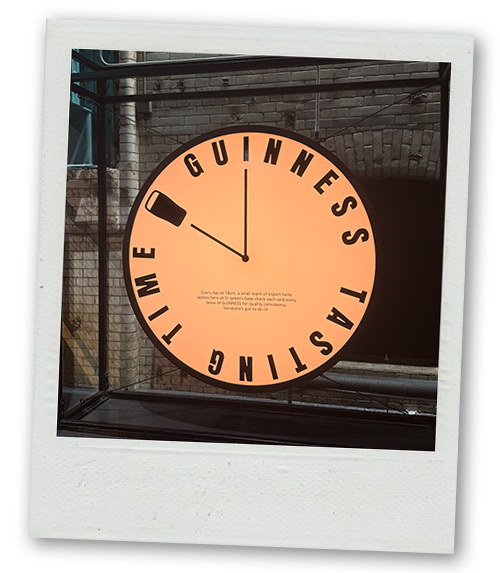A Polaroid of a clock that reads Guinness tasting time