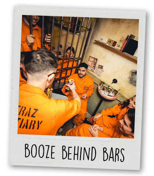 A Polaroid of a group of people taking part in Alcotraz with the caption Booze Behind Bars