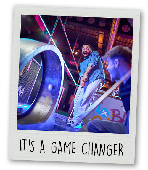 A Polaroid of a man playing mini golf on a loop the loop hole with the caption It's A Gamechanger