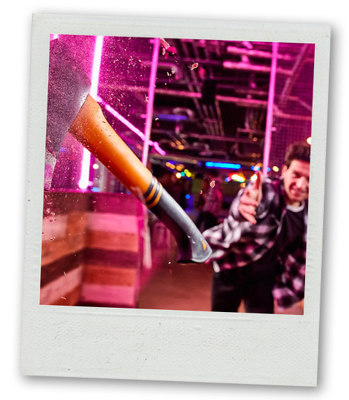 A Polaroid of a man doing axe throwing at Boom Battle Bar