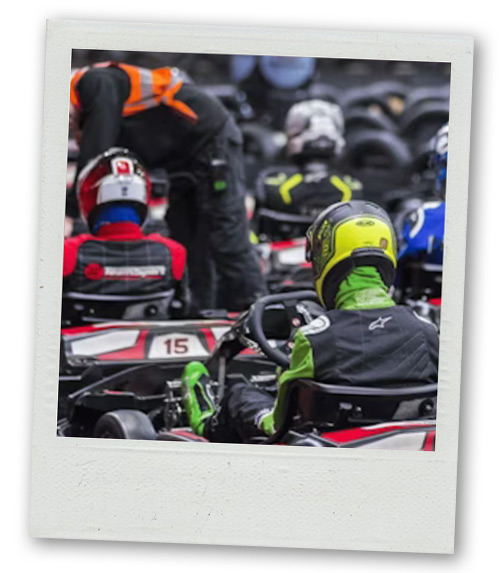 A Polaroid of several men lined up ready to do go karting