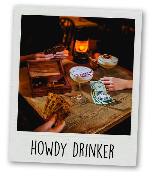 A Polaroid of a table that has cocktails, games and fake money on it with the caption Howdy Drinker
