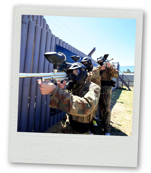 A Polaroid of three men stood together aiming their paintball guns