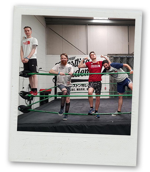 A Polaroid of four men standing in a wrestling ring
