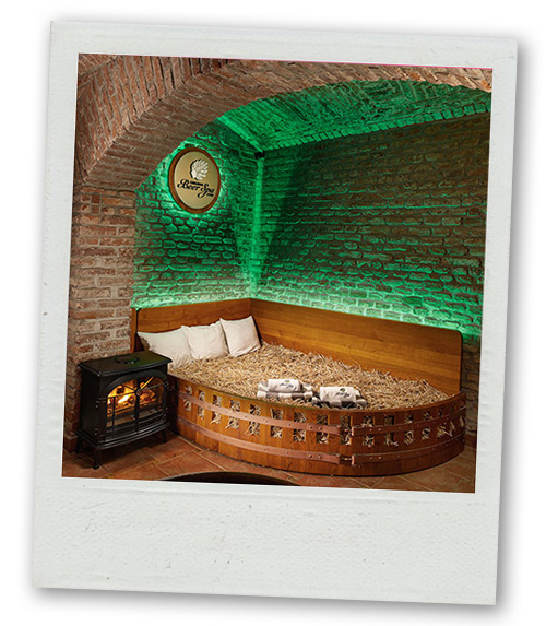 A Polaroid of a bed of hay in a room that has exposed brickwork and a cosy looking fire