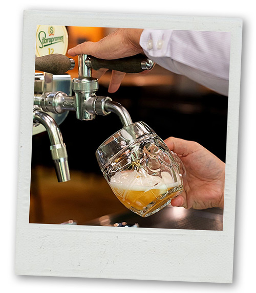 A Polaroid of a man pouring a beer from a beer tap reading Staropramen