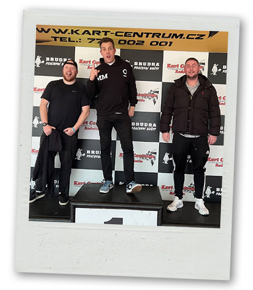 A Polaroid of three men posing on a podium as first, second and third