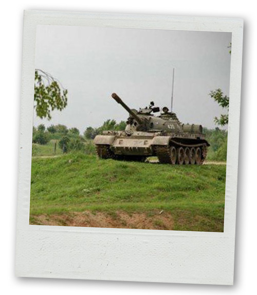 A Polaroid of a tank making its way over a small hill