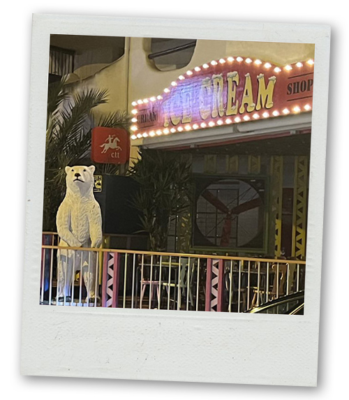 A Polaroid of a bar that has a statue of a polar bear outside it