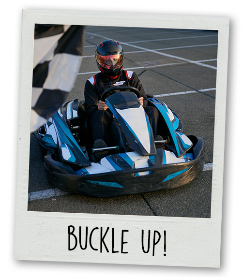 A Polaroid of a man go karting with the caption Buckle Up