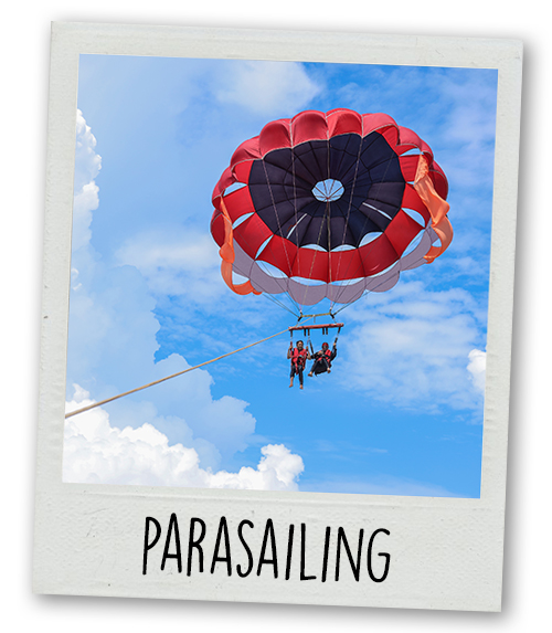 A Polaroid of two people parasailing with the caption Parasailing