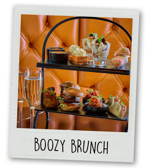 A Polaroid of an tiered afternoon tea with some glasses of prosecco with the caption Boozy Brunch