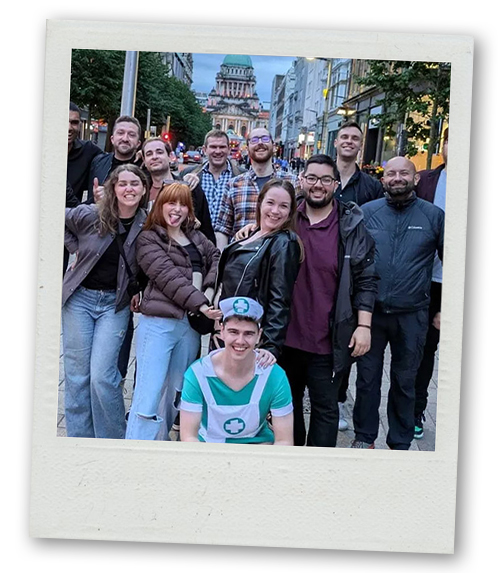 A Polaroid of a mixed gender group of people posing for a photo on a bar crawl with a stag dressed up as a nurse