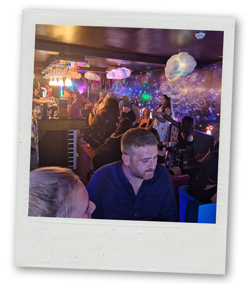 A Polaroid of a group of people enjoying the atmosphere of karaoke at the River Rooms
